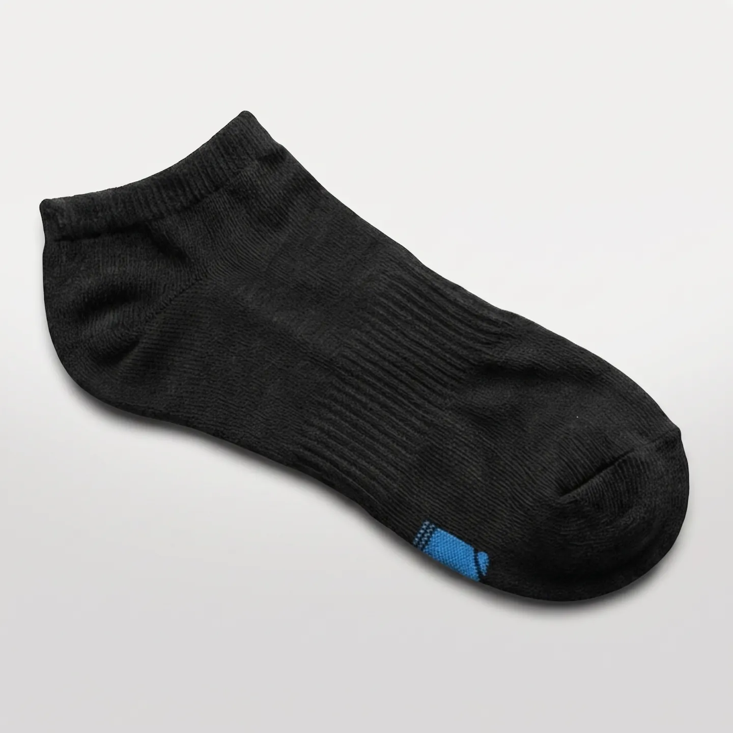 Flat lay of a clean black cotton no show sock with plush terry sole, cushioned heel, and seamless toe.